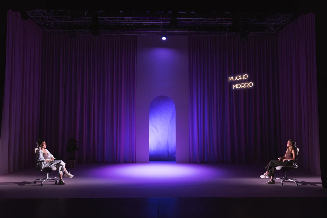 Dos intérpretes a ambos lados de un escenario iluminado en violeta — Arreglos Florales, Corporación Morritos
