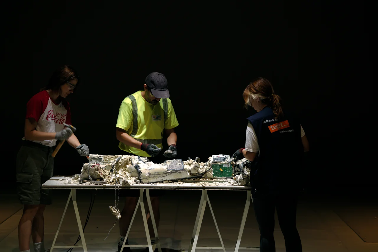 Tres intérpretes trabajando con objetos sobre una mesa — Ese Otro Lugar