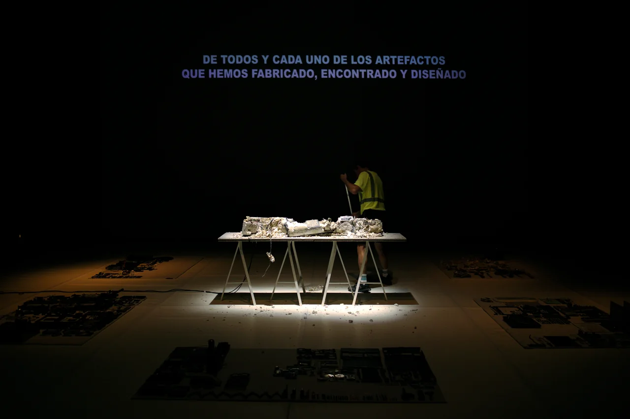 Mesa y objetos en una escena con proyección de texto — Ese Otro Lugar
